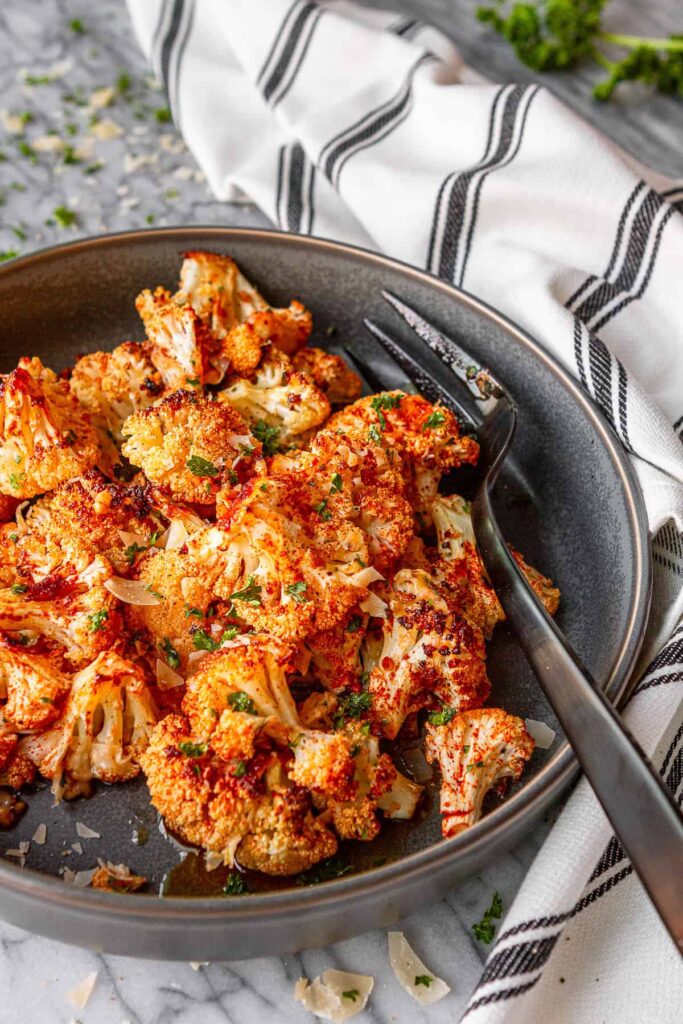 Roasted cauliflower florets topped with golden Parmesan and fresh parsley.